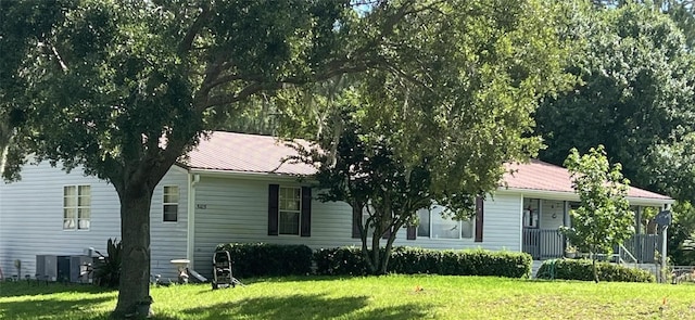 view of front of home with a front yard and central air condition unit