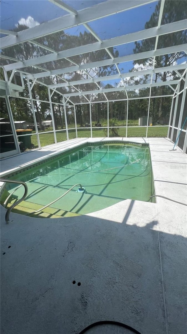 view of swimming pool with a lanai, a patio area, and a lawn