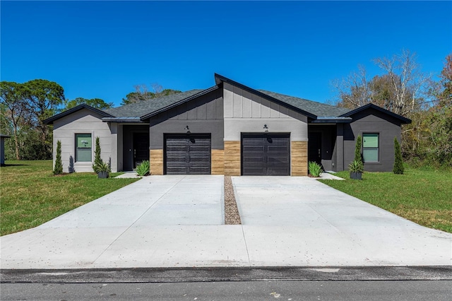 view of front of property featuring a garage, driveway, board and batten siding, and a front yard