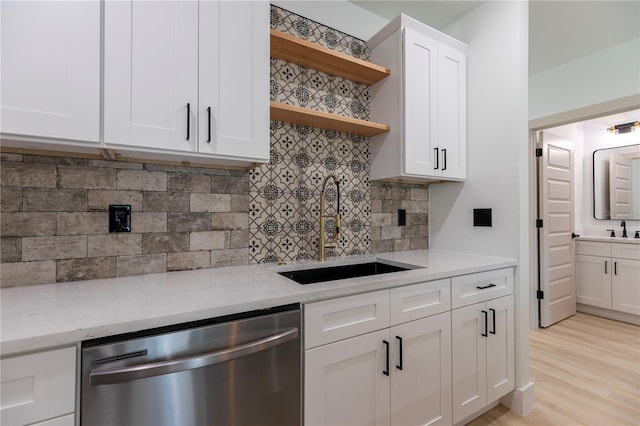 kitchen with a sink, light wood-style flooring, open shelves, and dishwasher