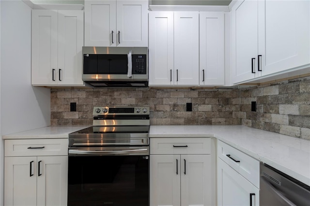 kitchen with appliances with stainless steel finishes, light stone countertops, white cabinets, and tasteful backsplash