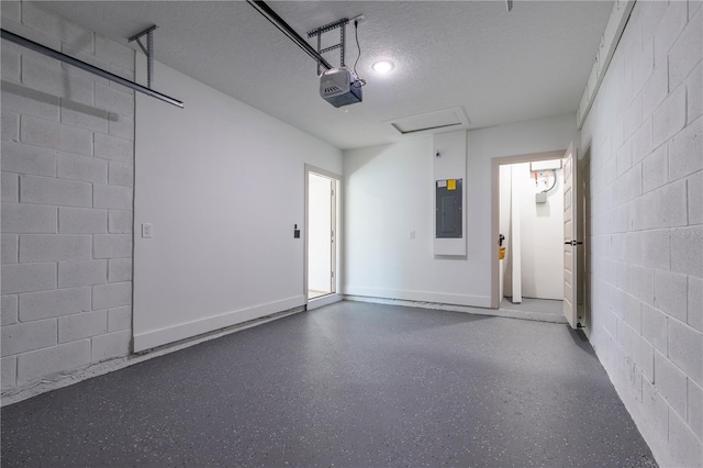 garage featuring a garage door opener, concrete block wall, electric panel, and baseboards