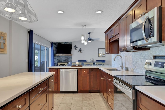 kitchen featuring lofted ceiling, sink, tasteful backsplash, pendant lighting, and stainless steel appliances