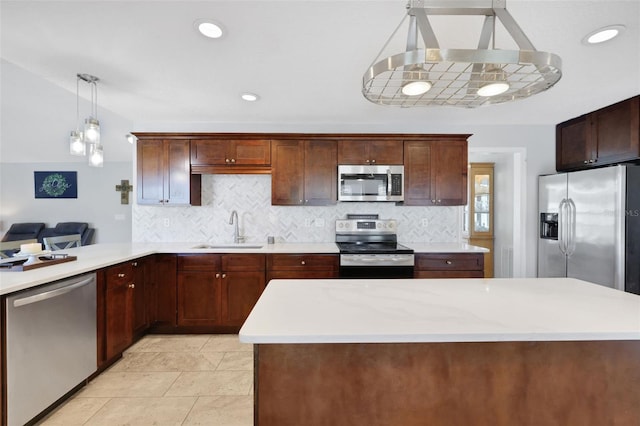 kitchen featuring hanging light fixtures, tasteful backsplash, appliances with stainless steel finishes, and sink