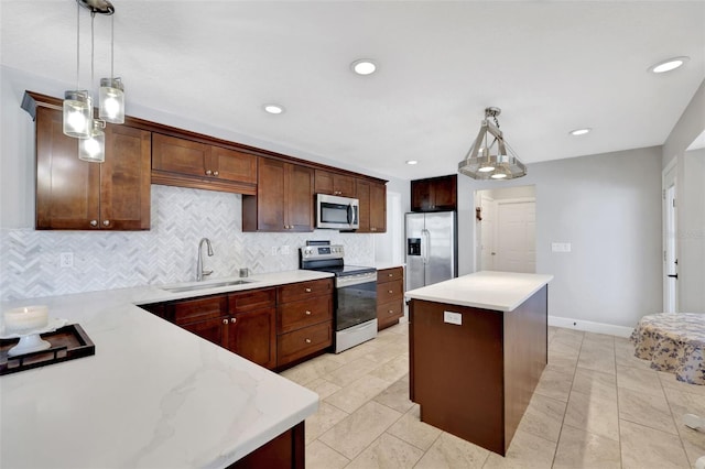 kitchen with sink, stainless steel appliances, hanging light fixtures, and a center island