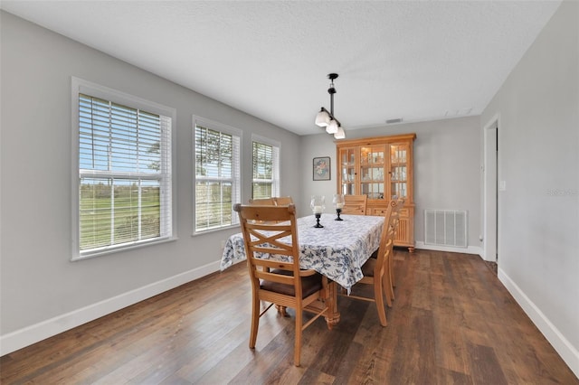 dining room with dark hardwood / wood-style floors and a textured ceiling