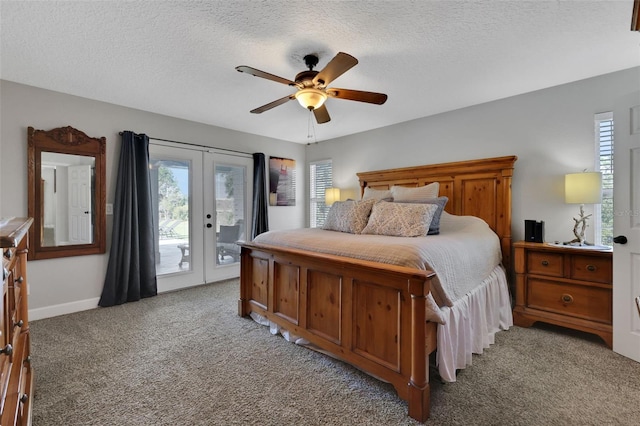 carpeted bedroom featuring french doors, access to exterior, multiple windows, and a textured ceiling