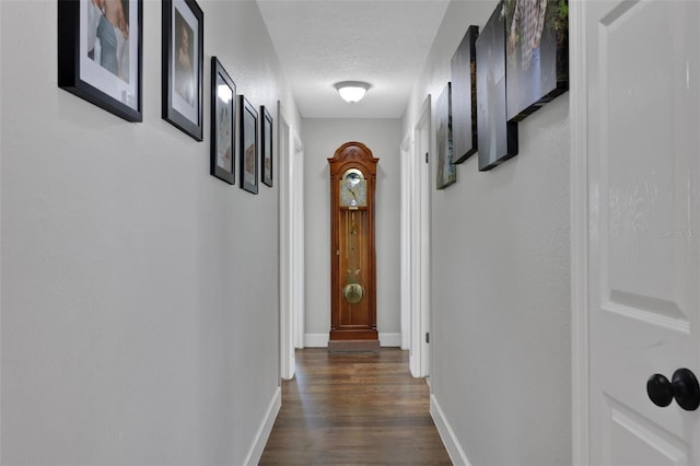 hall with dark hardwood / wood-style floors and a textured ceiling