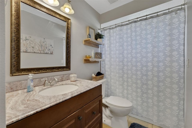 bathroom featuring tile patterned flooring, vanity, and toilet