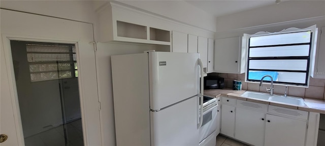 kitchen featuring white appliances, tile countertops, sink, and white cabinets