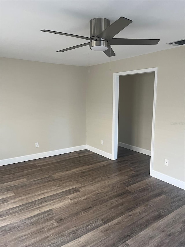 spare room with dark wood-type flooring and ceiling fan