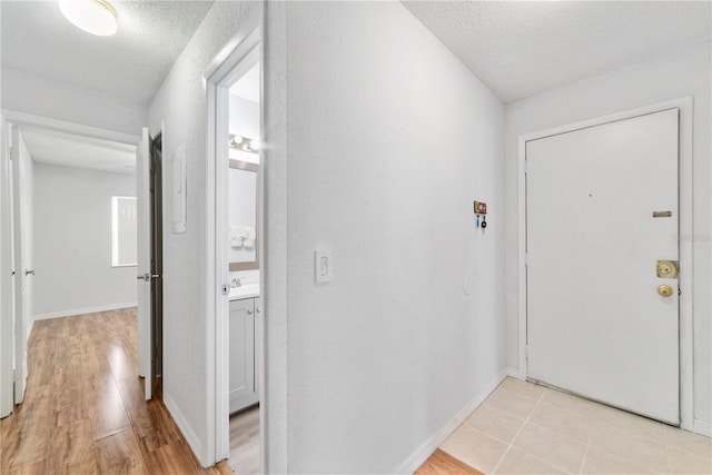 interior space with sink, light hardwood / wood-style flooring, and a textured ceiling