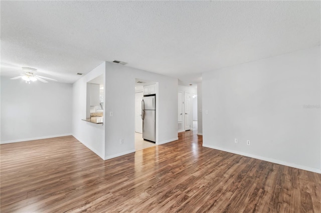 unfurnished living room featuring ceiling fan, a textured ceiling, and light wood-type flooring