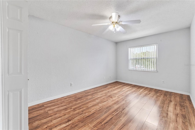 empty room with ceiling fan, hardwood / wood-style floors, and a textured ceiling