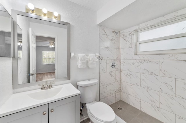 bathroom featuring vanity, toilet, and a tile shower