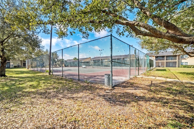 view of tennis court with a lawn