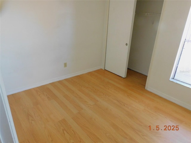 unfurnished bedroom with a closet and light wood-type flooring