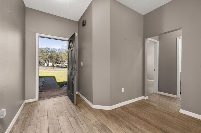 foyer entrance featuring wood finished floors and baseboards