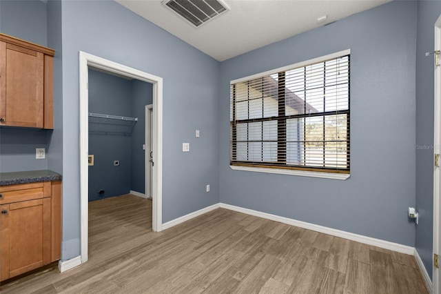 interior space featuring light wood finished floors, visible vents, and baseboards