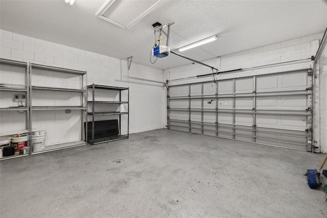 garage with a garage door opener and concrete block wall