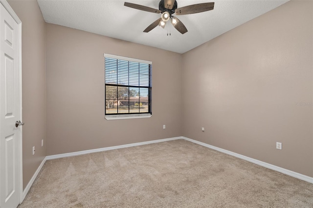 spare room featuring carpet flooring, ceiling fan, a textured ceiling, and baseboards