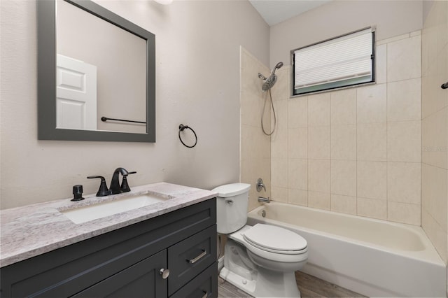 bathroom featuring toilet, shower / bathtub combination, wood finished floors, and vanity