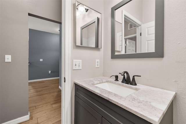 bathroom featuring wood finished floors, vanity, and baseboards