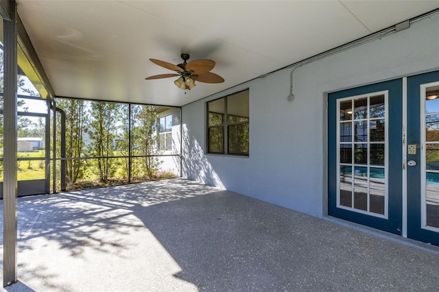 unfurnished sunroom featuring ceiling fan