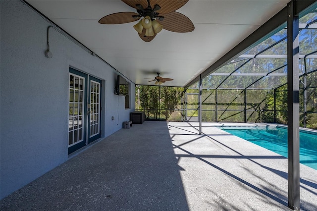 exterior space featuring a lanai, a ceiling fan, and an outdoor pool