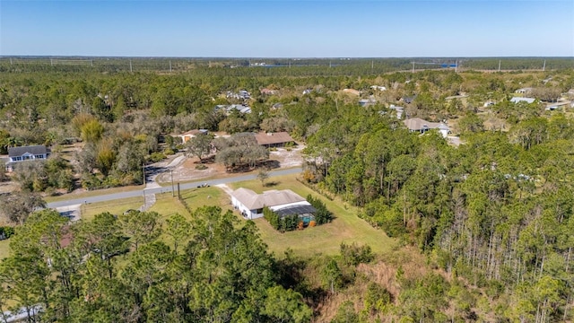 birds eye view of property featuring a forest view