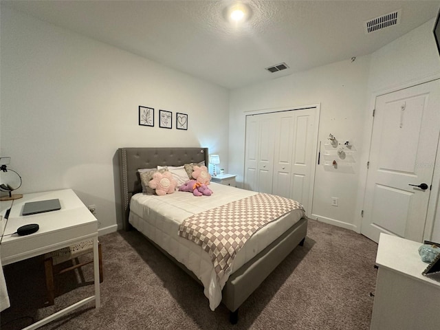 carpeted bedroom with a closet and a textured ceiling