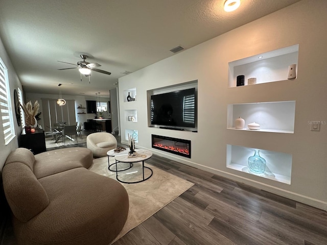 living room with dark wood-type flooring and ceiling fan