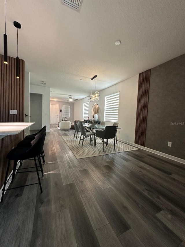 dining room featuring ceiling fan, a textured ceiling, and dark hardwood / wood-style flooring