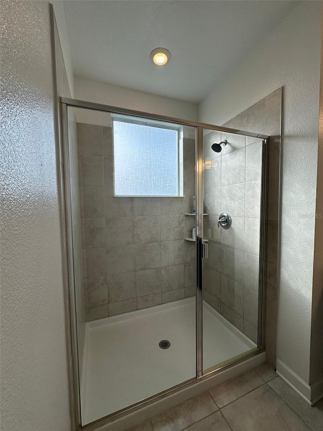 bathroom featuring tile patterned floors and a shower with shower door