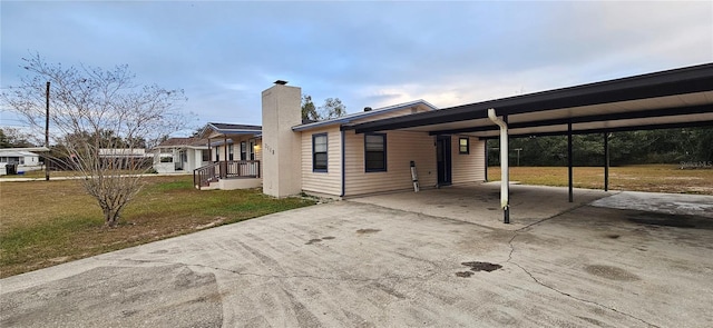 view of front of property featuring a carport and a front lawn