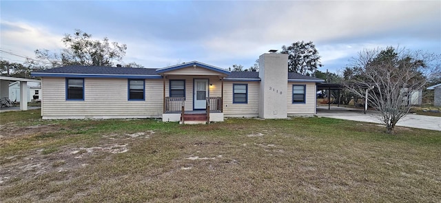 view of front of property featuring a front yard and a carport