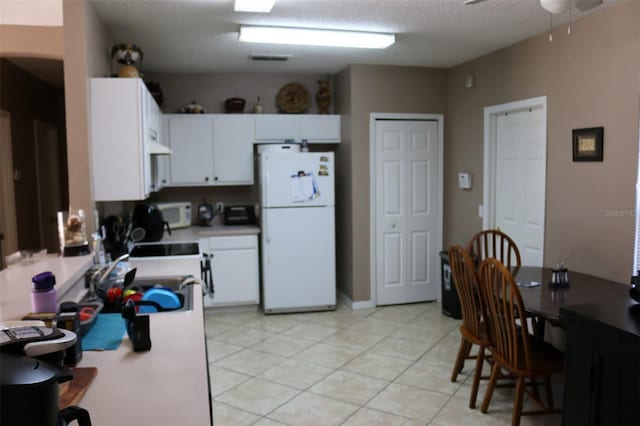 kitchen featuring white cabinetry, a textured ceiling, light tile patterned floors, ceiling fan, and white appliances