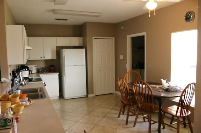 350 Chelmsford Ct, Kissimmee, FL 34758 - kitchen with white appliances, a ceiling fan, light tile patterned floors, white cabinets, and extractor fan