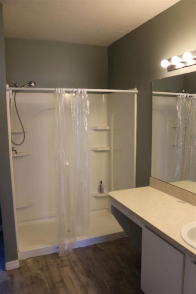 350 Chelmsford Ct, Kissimmee, FL 34758 - full bath with a shower with shower curtain, wood finished floors, and vanity