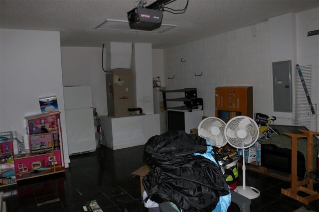 350 Chelmsford Ct, Kissimmee, FL 34758 - garage with electric panel, a garage door opener, concrete block wall, freestanding refrigerator, and electric water heater