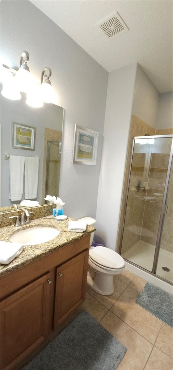 bathroom featuring vanity, an enclosed shower, and tile patterned flooring