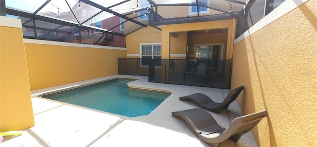 view of pool featuring glass enclosure and a patio