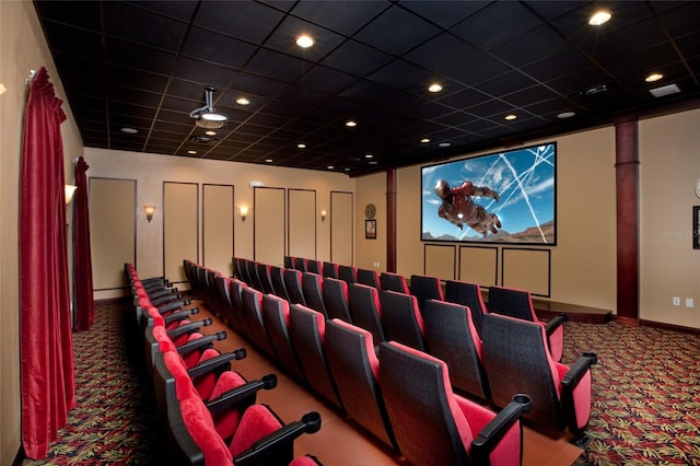 cinema room with carpet floors and a drop ceiling