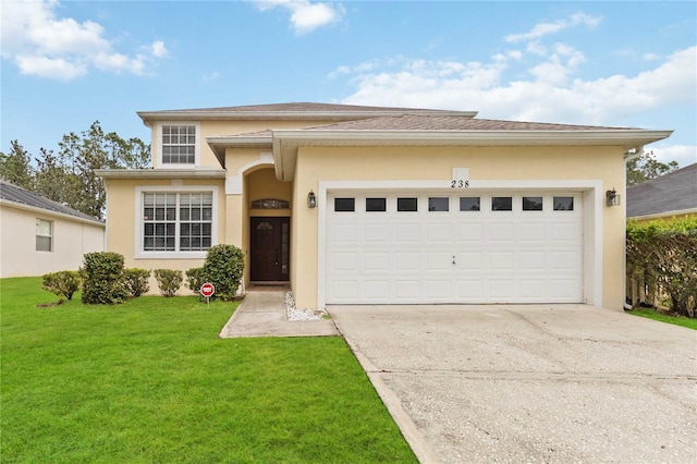 view of front of property with a garage, a front yard, concrete driveway, and stucco siding