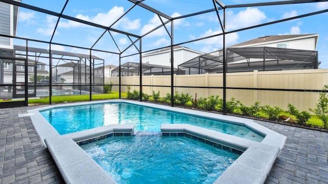 view of pool with an in ground hot tub, a patio, and glass enclosure