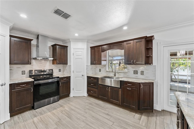 kitchen with dark brown cabinetry, wall chimney exhaust hood, stainless steel electric stove, and sink