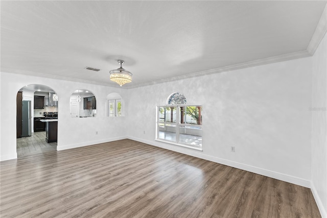 unfurnished living room with hardwood / wood-style flooring and ornamental molding