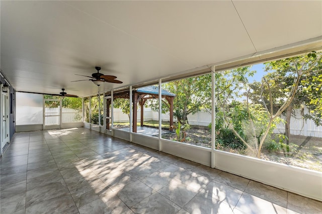 unfurnished sunroom with ceiling fan