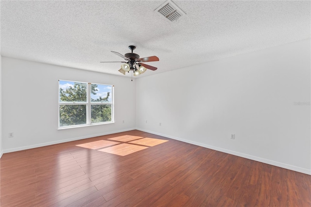 spare room featuring ceiling fan, wood-type flooring, and a textured ceiling