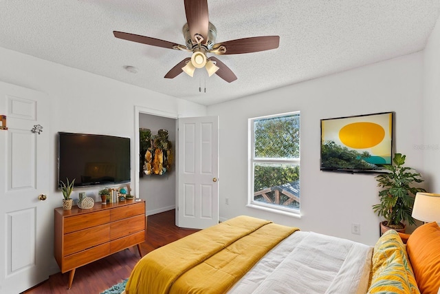 bedroom with dark wood-style floors, ceiling fan, and a textured ceiling